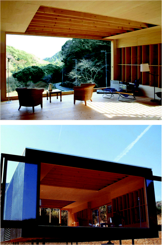 Two Photographs of the Mirai Nihon Off-Grid House. (1) The house is made up of wood with two cane chairs and a wooden table placed towards the left side. On the right side is kept a chair and table, a table lamp and some electronic equipments.. The house is overlooking a road with mountain covered trees. (2) Photograph describing the Front view of the house. The house is above ground supported with some bars. The doors are open and a man is sitting on the right cane chair.